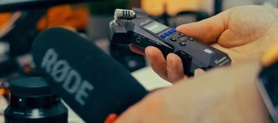 Persona grabando su voz frente a una computadora con un micrófono conectado