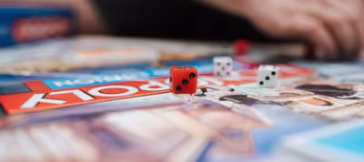 Juegos de mesa como Jenga, Uno y fichas de Monopolio sobre una mesa en una reunión de jóvenes