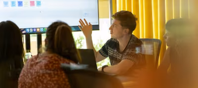 Equipo de líderes de jóvenes compartiendo ideas alrededor de una mesa de trabajo