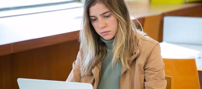 Estudiante con una computadora portátil tomando un curso en línea de University of the People