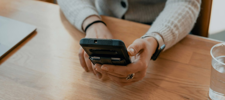 Teléfono con una aplicación de finanzas personales mostrando el registro de gastos con fotografías de recibos