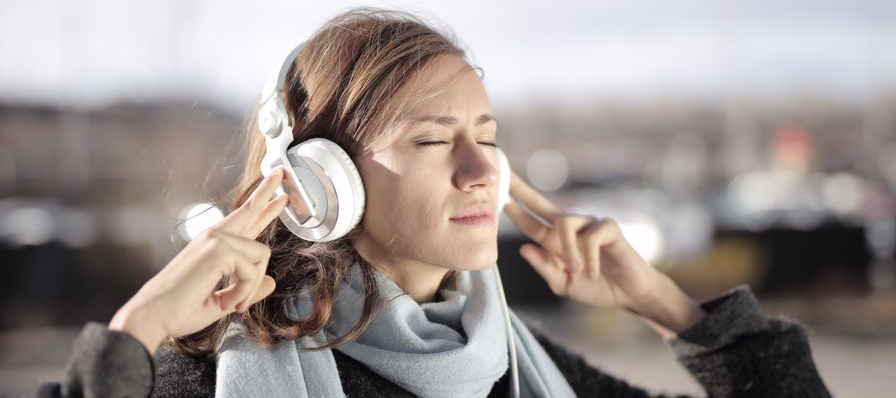 Líder de jóvenes escuchando un audiolibro mientras viaja en transporte público