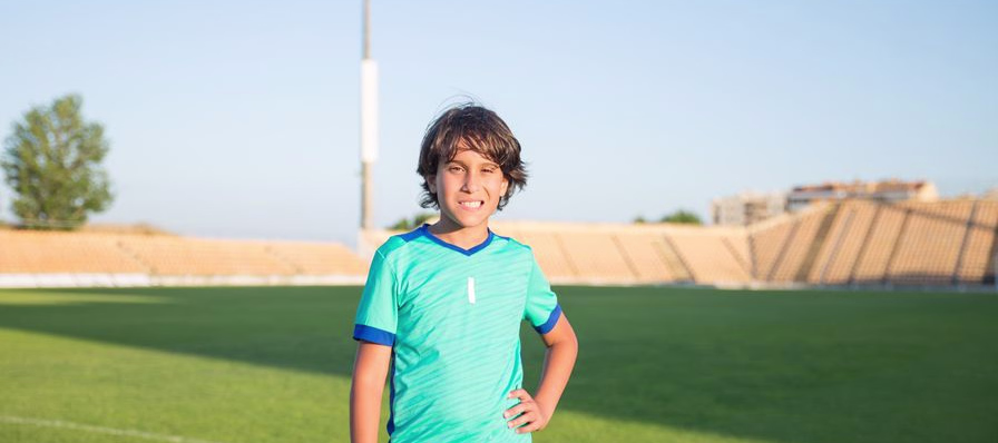 Grupo de jóvenes jugando fútbol pingüino en un campo con las piernas atadas con tiras de tela