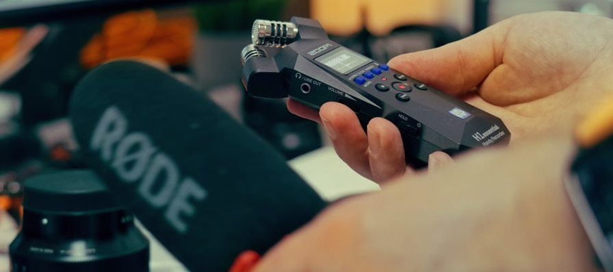 Persona grabando su voz frente a una computadora con un micrófono conectado