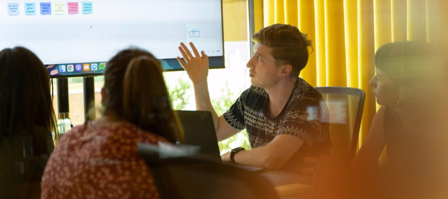 Equipo de líderes de jóvenes compartiendo ideas alrededor de una mesa de trabajo